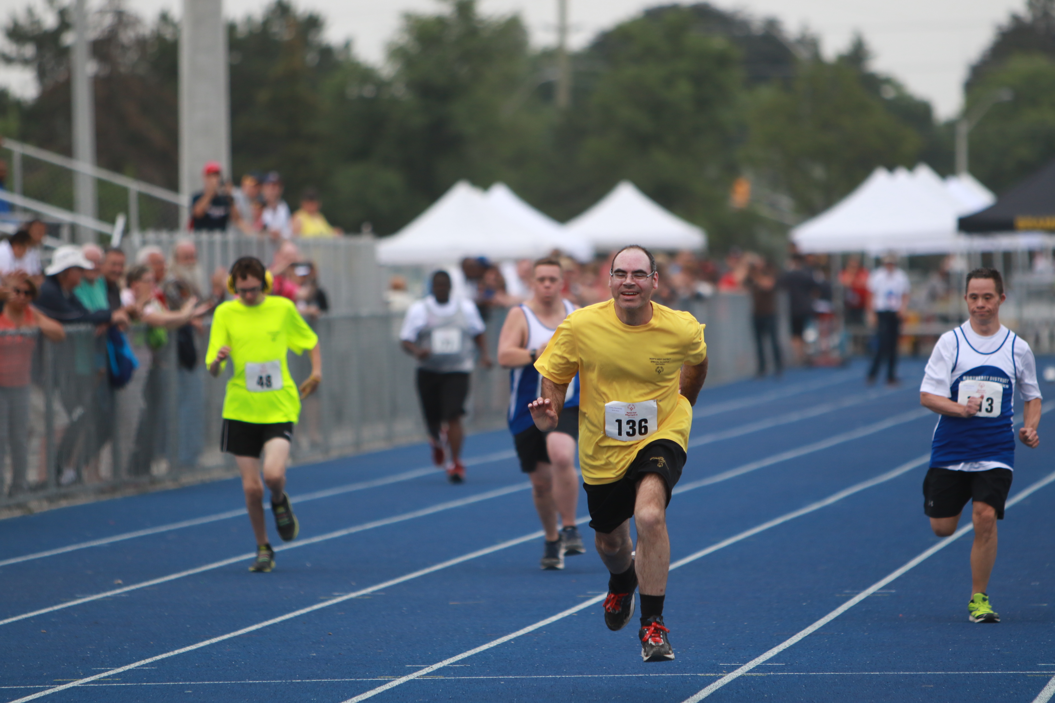 Four track athletes sprinting.