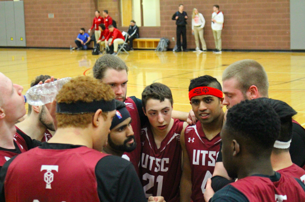Basketball players in a group huddle.