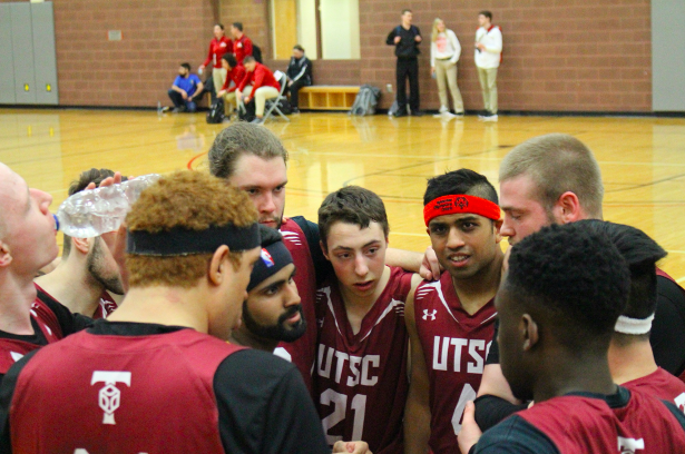 Basketball players in a group huddle. 